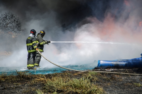 2 firefighters putting out brush fire