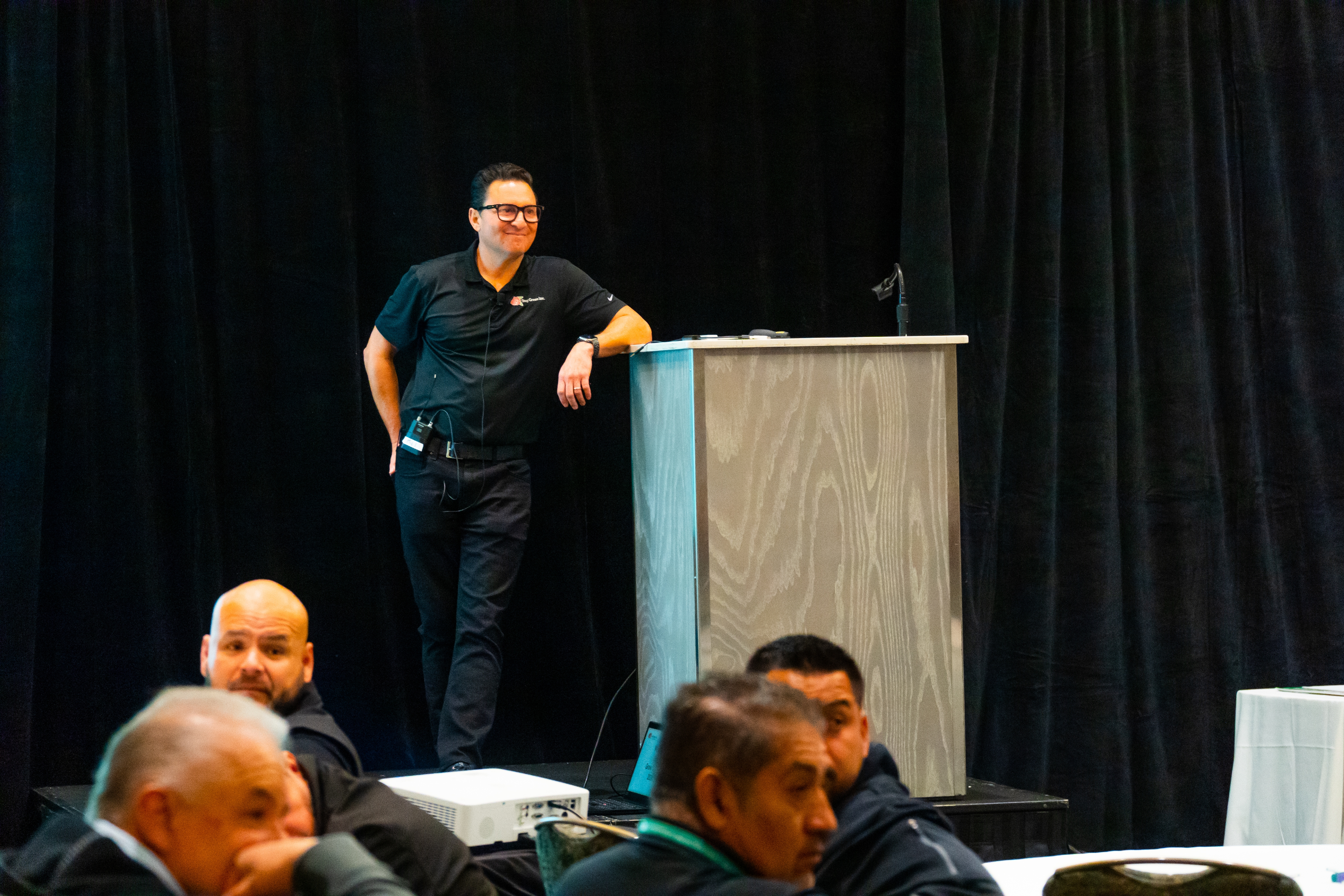 Stay Green Rep leaning on a podium with hand on hip, smiling