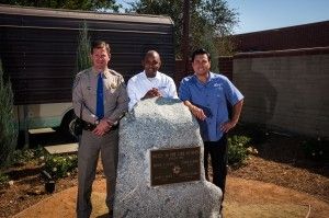 (From left) CHP Capt. Ed Krusey; Curtis Woods, general manager of Eternal Valley Memorial Park and Mortuary; and Chris Angelo, CEO of Stay Green Inc., pose for a photo at a memorial for four CHP officers killed in the 1970 shootout known as the Newhall Incident. The memorial is located outside the CHP’s Newhall Area Station and was completed through a partnership between Stay Green and Eternal Valley.